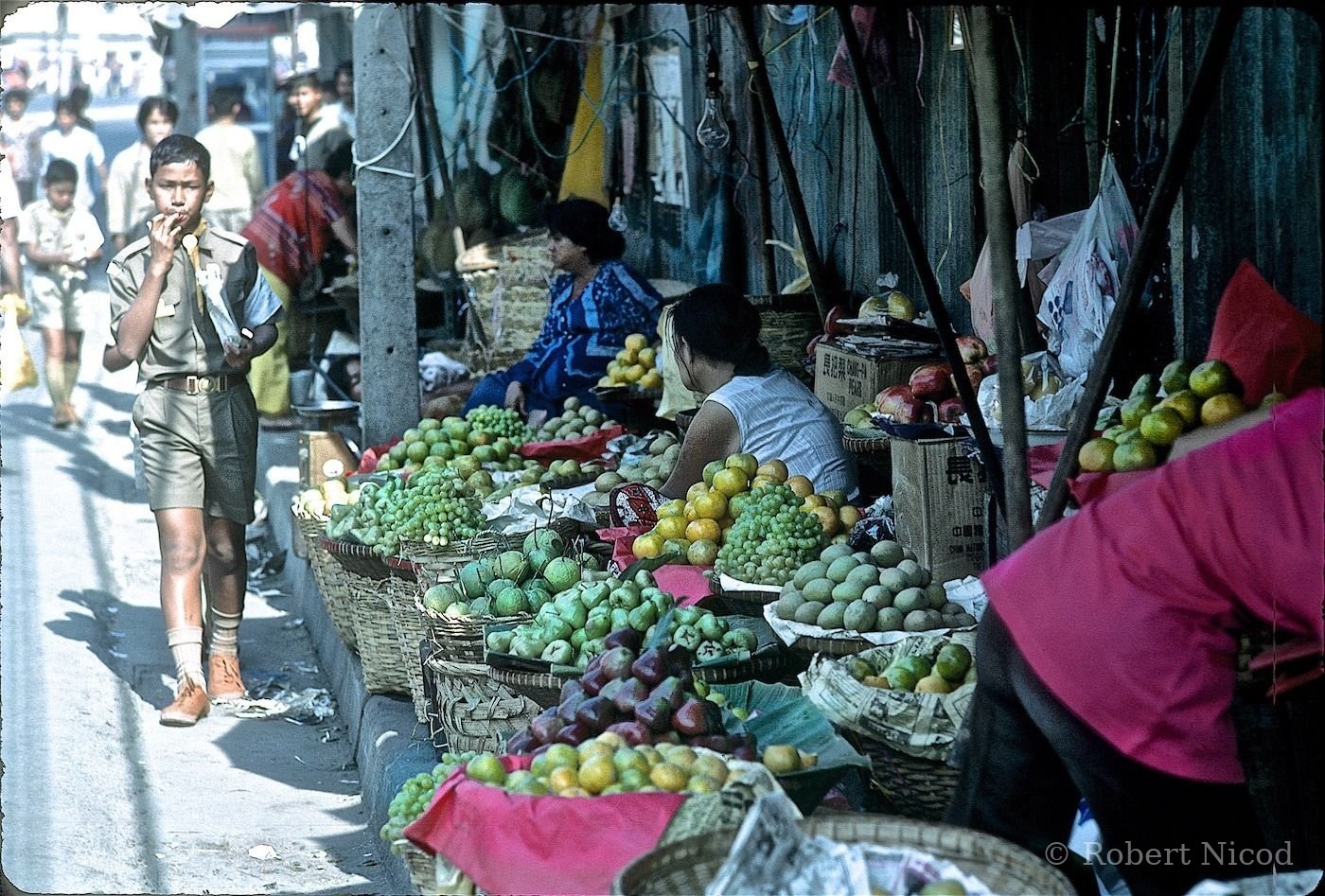 Reportage Thaïlande 1980 — Un jeune scout traverse le marché, Bangkok 1980